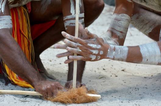 Aboriginal warriors men demonstrate fire making craft