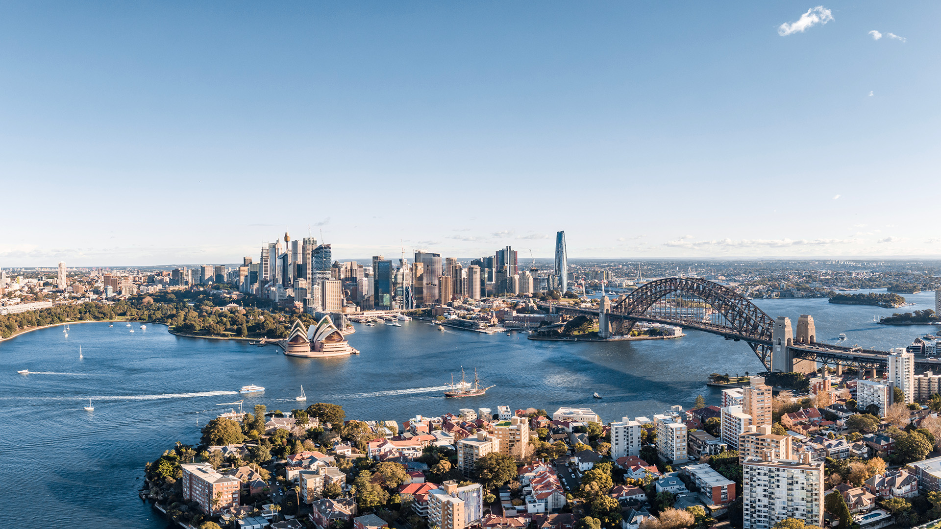 an aerial view of Sydney Harbour in Australia with iconic landmarks including Sydney Opera House and Sydney Harbour Bridge