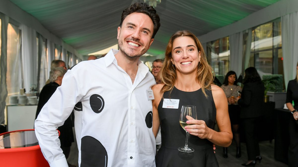 A man and woman pose in front of the party.